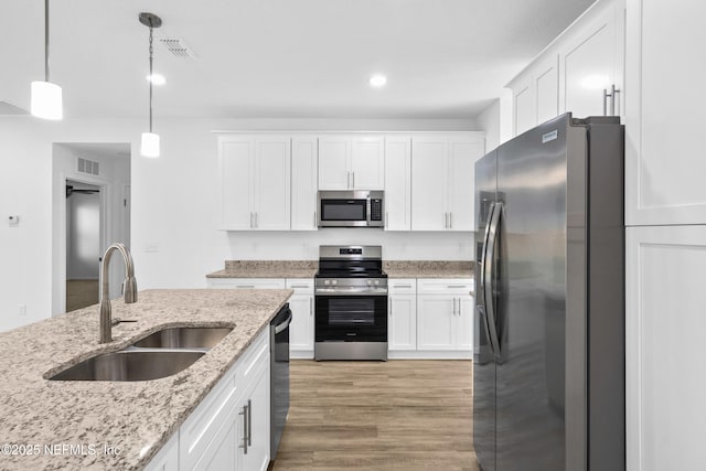 kitchen with visible vents, light wood finished floors, a sink, white cabinets, and appliances with stainless steel finishes