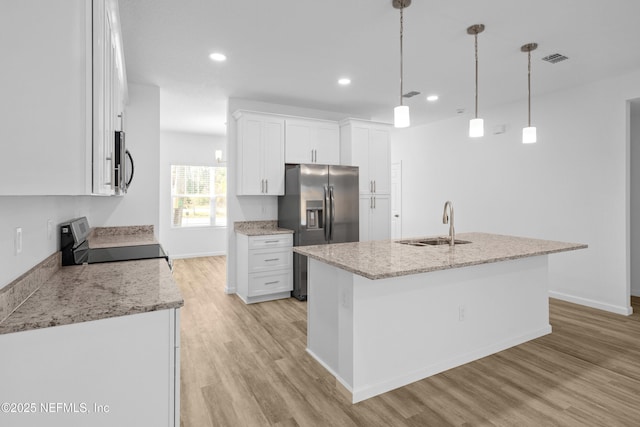 kitchen featuring a sink, stainless steel appliances, light wood-style flooring, and white cabinetry