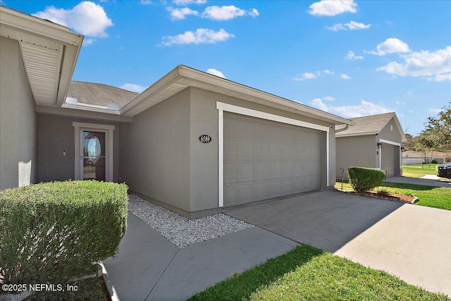 view of property exterior featuring stucco siding, an attached garage, and concrete driveway