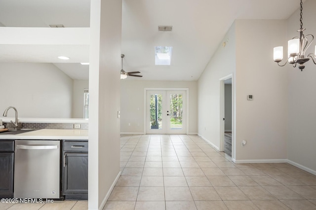 kitchen featuring lofted ceiling, light tile patterned floors, a sink, light countertops, and stainless steel dishwasher