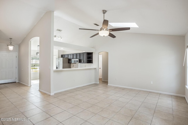 unfurnished living room featuring arched walkways, light tile patterned flooring, ceiling fan, and lofted ceiling