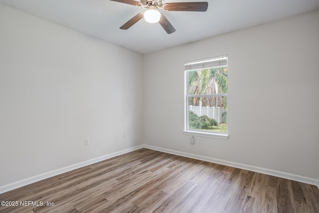 empty room featuring ceiling fan, baseboards, and wood finished floors