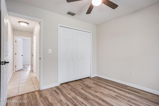 unfurnished bedroom featuring a closet, wood finished floors, visible vents, and baseboards