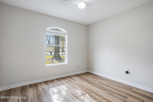 unfurnished room with ceiling fan, light wood-style flooring, and baseboards