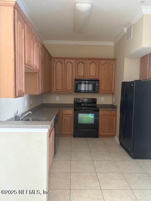 kitchen with light tile patterned floors, visible vents, ornamental molding, a sink, and black appliances