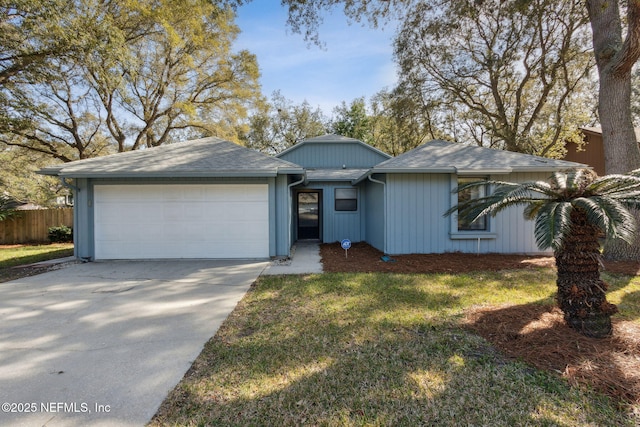 ranch-style home with a shingled roof, fence, driveway, and an attached garage