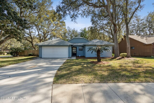 view of front of home featuring a garage, driveway, fence, and a front yard