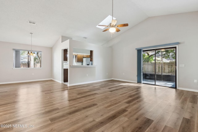 unfurnished living room featuring a skylight, visible vents, a wealth of natural light, and wood finished floors