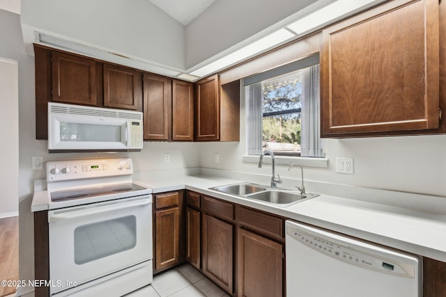 kitchen with white appliances, light countertops, and a sink