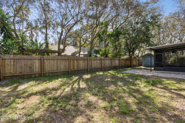 view of yard featuring a storage shed, an outbuilding, and a fenced backyard