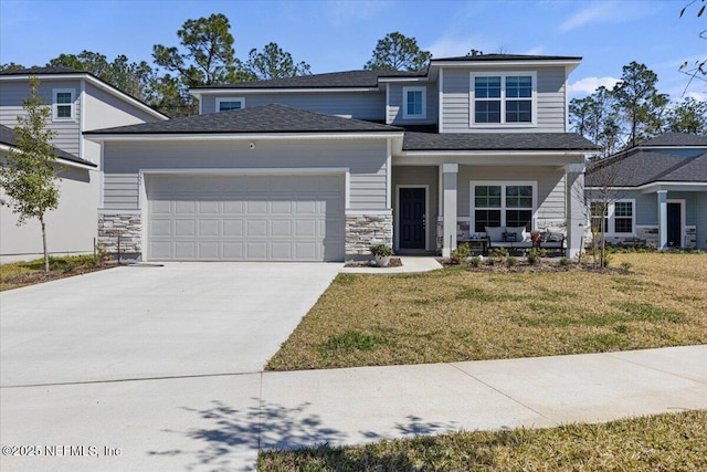 view of front of home with a porch, an attached garage, stone siding, driveway, and a front yard