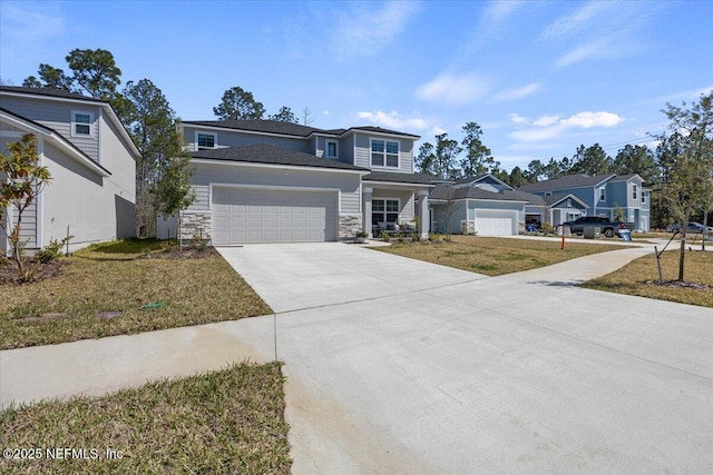 traditional-style house featuring an attached garage, stone siding, a front lawn, and concrete driveway