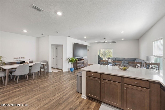 kitchen featuring a textured ceiling, recessed lighting, visible vents, light countertops, and dark wood-style floors