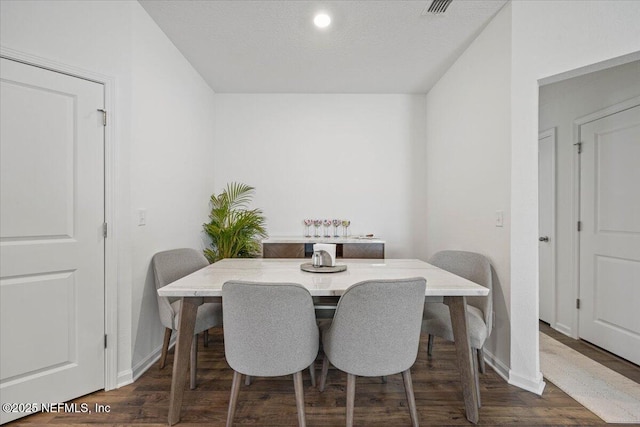 dining area with dark wood finished floors and baseboards