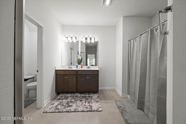 bathroom with double vanity, toilet, a sink, a textured ceiling, and tile patterned floors