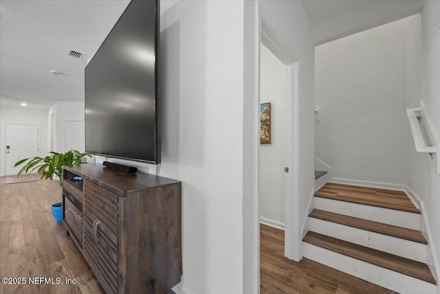 stairs featuring baseboards, visible vents, and wood finished floors