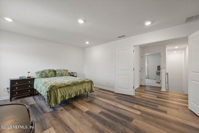 bedroom with recessed lighting, visible vents, and wood finished floors