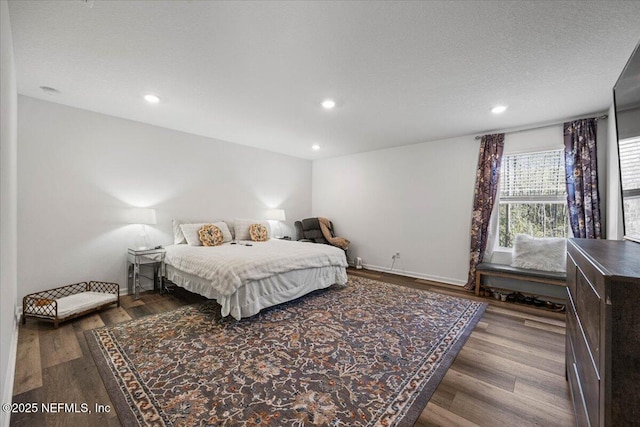 bedroom with a textured ceiling, baseboards, wood finished floors, and recessed lighting