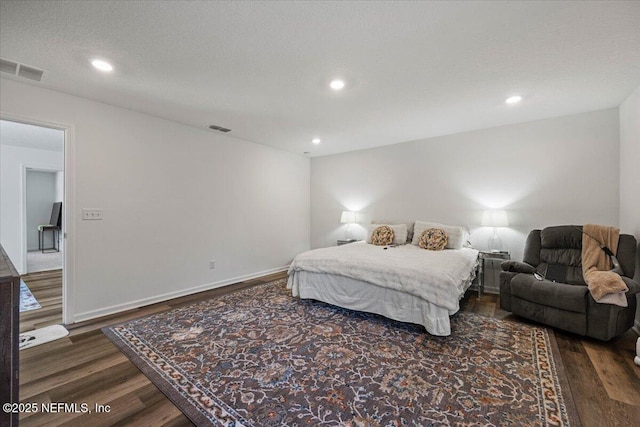 bedroom with dark wood-style flooring, visible vents, and recessed lighting