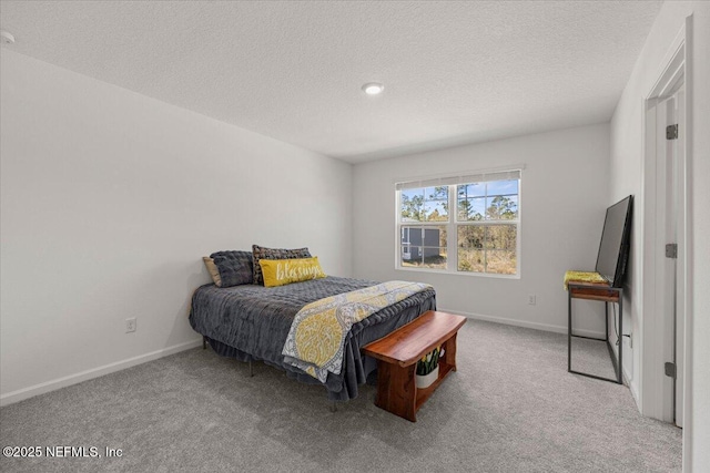 carpeted bedroom with a textured ceiling and baseboards