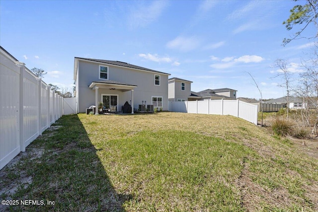 rear view of house featuring a fenced backyard, a lawn, and stucco siding