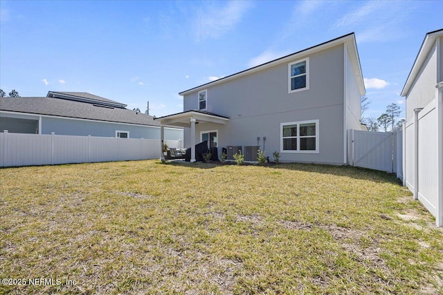 back of property featuring a fenced backyard, a gate, central AC unit, and a lawn