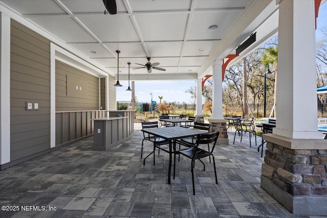 view of patio / terrace with ceiling fan, outdoor dining space, and fence