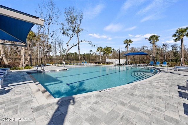 pool featuring fence and a patio