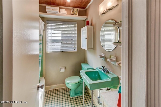 bathroom featuring plenty of natural light, a sink, toilet, and baseboards