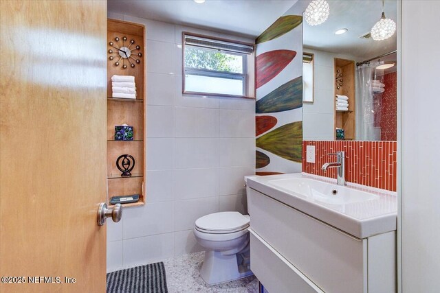 bathroom featuring a shower with curtain, tile walls, toilet, and vanity