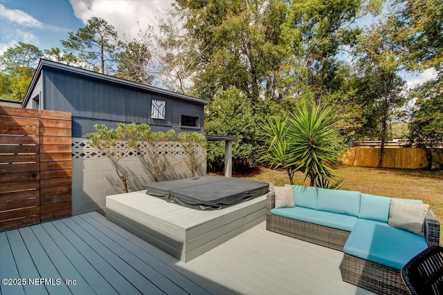 deck with fence, outdoor lounge area, and a covered hot tub