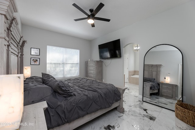 bedroom featuring marble finish floor, ceiling fan, arched walkways, and connected bathroom