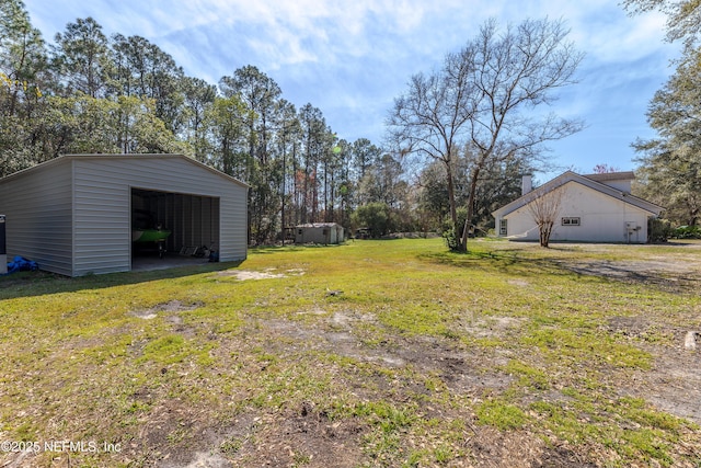 view of yard with a pole building, a detached garage, driveway, and an outdoor structure