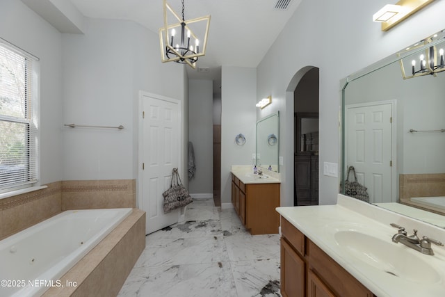 bathroom with a whirlpool tub, an inviting chandelier, marble finish floor, a sink, and two vanities