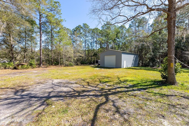 view of yard with a garage and an outbuilding