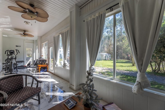 sunroom / solarium featuring a ceiling fan