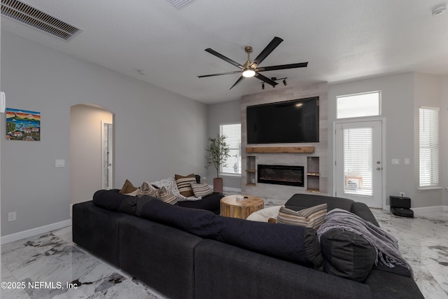 living area with a wealth of natural light, marble finish floor, visible vents, and a fireplace