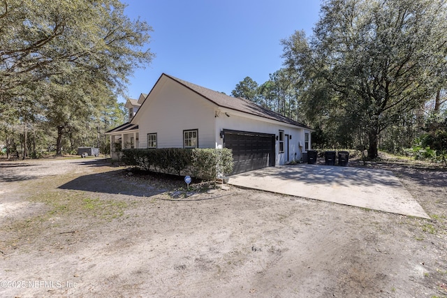 view of side of home with a garage and driveway