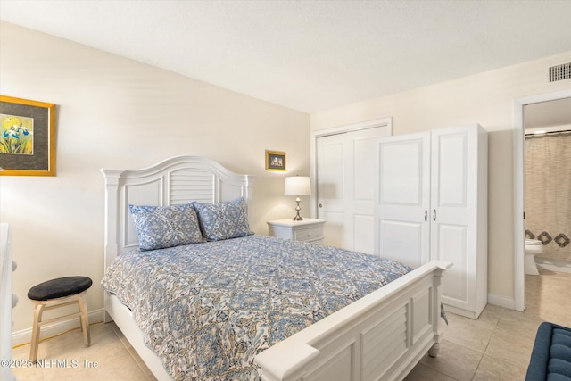 bedroom with light tile patterned flooring, baseboards, and a closet