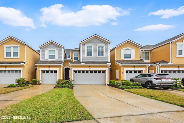 view of property with stucco siding, an attached garage, and driveway