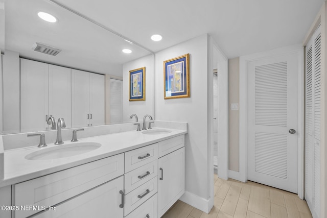 full bath featuring a closet, visible vents, a sink, and double vanity