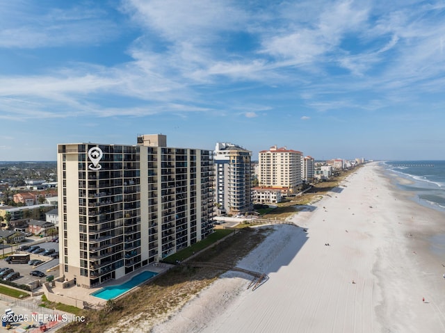 drone / aerial view featuring a water view, a view of city, and a view of the beach