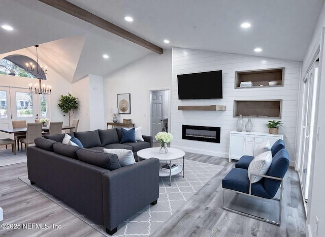 living area with vaulted ceiling with beams, a large fireplace, recessed lighting, an inviting chandelier, and wood finished floors