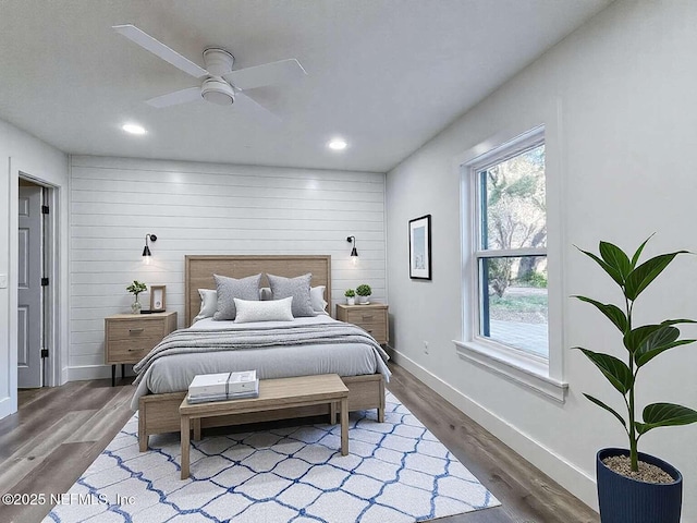 bedroom with wood finished floors, recessed lighting, wooden walls, baseboards, and ceiling fan