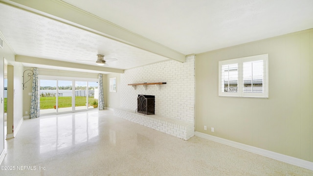 unfurnished living room featuring baseboards, a ceiling fan, speckled floor, a fireplace, and beam ceiling