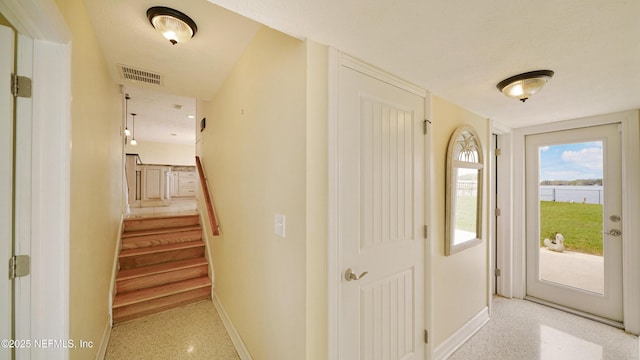 corridor featuring light speckled floor, stairs, visible vents, and baseboards