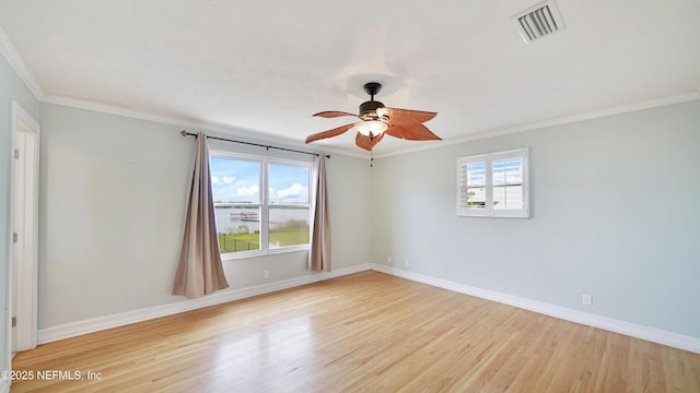 spare room featuring visible vents, baseboards, and wood finished floors