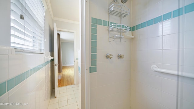 full bathroom with ornamental molding, tiled shower, tile walls, and tile patterned floors