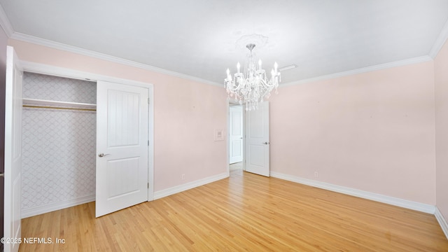 unfurnished bedroom featuring baseboards, crown molding, a notable chandelier, and light wood finished floors