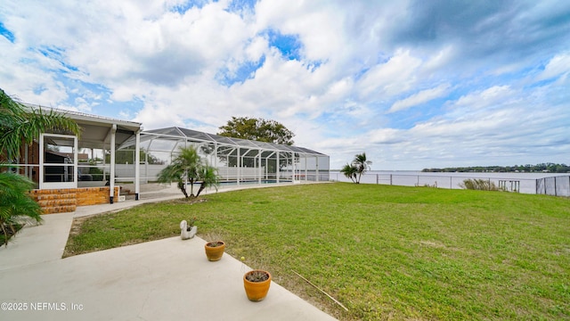 view of yard with a sunroom, a water view, a lanai, fence, and a patio area